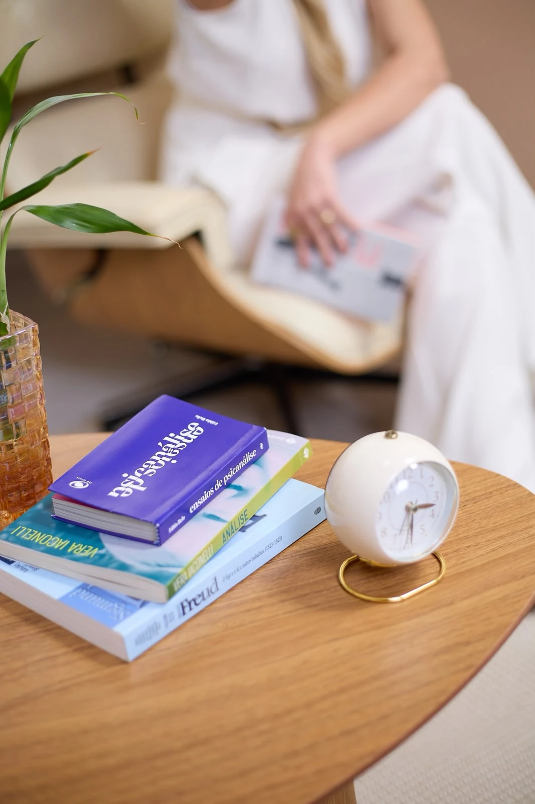 Livros e um relógio sobre a mesa do consultório